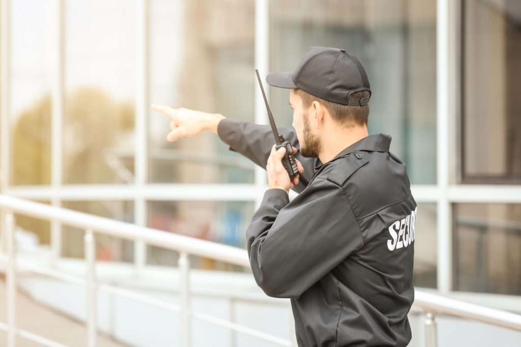 Security officer communicating by radio during a property patrol
